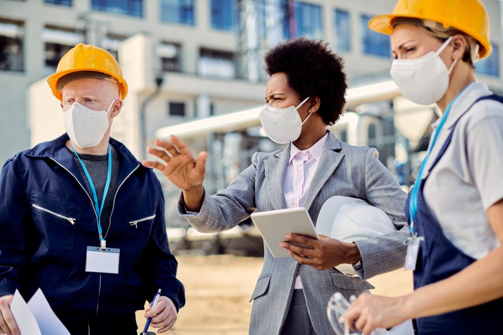 Architect and civil engineers in face masks at a construction site