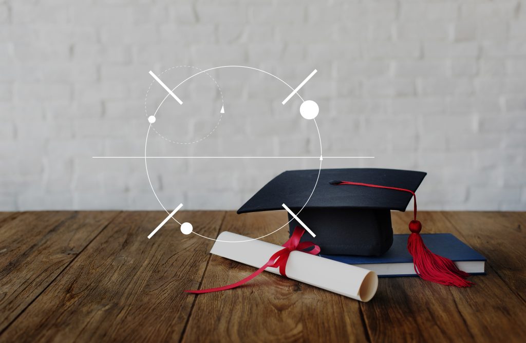 Graduation cap and diploma on a wooden table