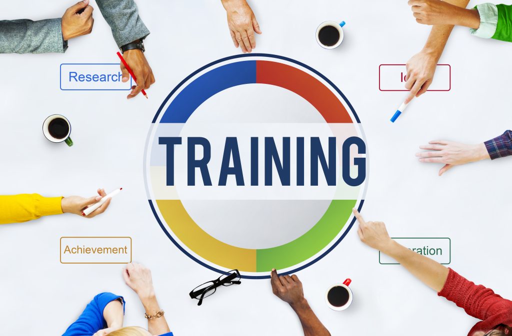 Hands around a table with a large TRAINING circle graphic