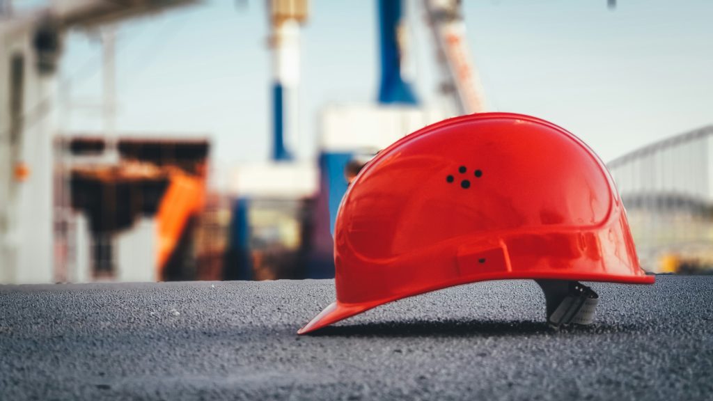 Red safety helmet on the ground at an industrial site